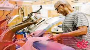 آقایی در حال انجام دادن کار با اتوپرس صنعتی در خشکشویی، و بررسی مشکلات دستگاه اتوپرس صنعتی